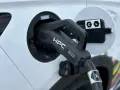 Ładowanie samochodu elektrycznego. Wtyczka HPC podłączona do portu ładowania, zapewniająca przepływ napięcia.