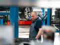 Mechanik w warsztacie, samochód na podnośniku. Sprawdza sprzęt do dynamiczna wymiana oleju dsg cena.