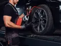 Mechanik sprawdza opony Kormoran, zastanawiając się, gdzie produkowane są te solidne opony.