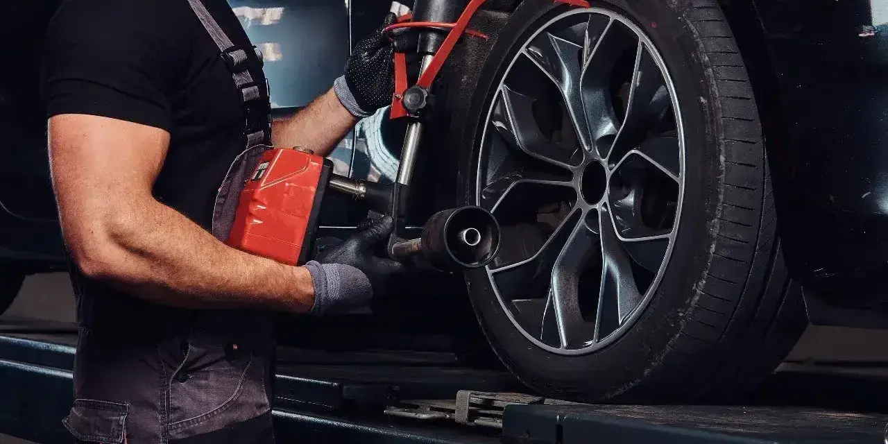 Mechanik sprawdza opony Kormoran, zastanawiając się, gdzie produkowane są te solidne opony.