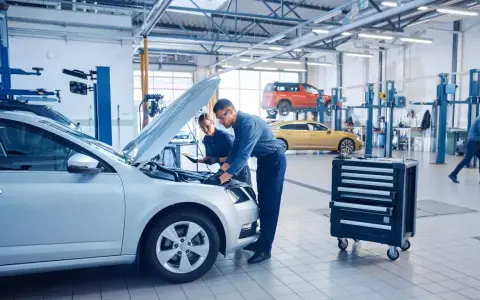 Mechanicy badają silnik srebrnego auta, szukając objawów uszkodzonego sterownika LPG.