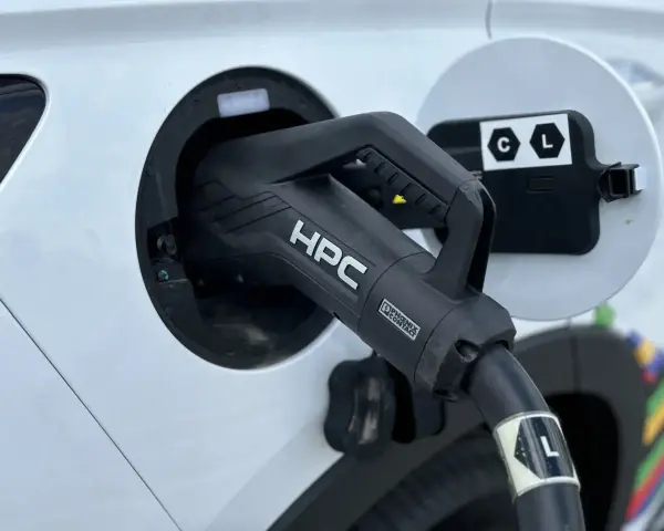 Ładowanie samochodu elektrycznego. Wtyczka HPC podłączona do portu ładowania, zapewniająca przepływ napięcia.
