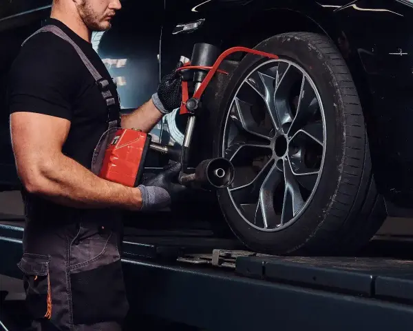Mechanik sprawdza opony Kormoran, zastanawiając się, gdzie produkowane są te solidne opony.