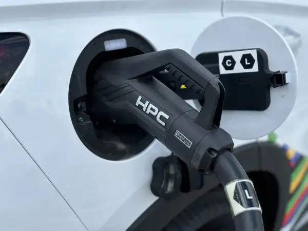 Ładowanie samochodu elektrycznego. Wtyczka HPC podłączona do portu ładowania, zapewniająca przepływ napięcia.